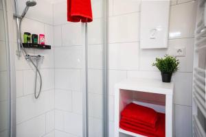 La salle de bains est pourvue d'une douche et d'une serviette rouge. dans l'établissement Ruhig und Zentral. Einzigartig im Südviertel, à Essen