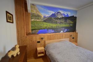 a bedroom with a large painting on the wall at Ca' Elide in Aosta