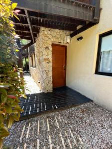un bâtiment avec une porte en bois sur son côté dans l'établissement Complejo Agapanto, à Mar de las Pampas