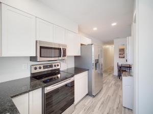 una cucina con armadietti bianchi ed elettrodomestici in acciaio inossidabile di Bayshore Home 6250 a Tampa