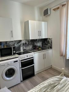 a kitchen with white cabinets and a stove and a dishwasher at 12 Worcester street. Wolverhampton wv24ld in Wolverhampton
