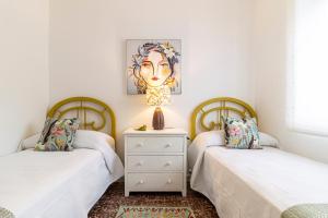 two twin beds in a room with white walls at El Balcón de la Bodega - Luxurious apartment in Jerez with gym in Jerez de la Frontera