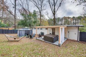 a small white house with a hammock in a yard at Modern Atlanta Retreat Private Hot Tub and Yard! in Atlanta