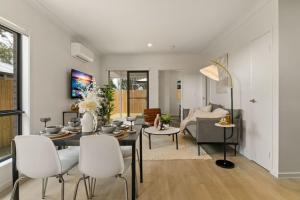 Un comedor y una sala de estar con mesa y sillas. en Cozy 2BR brandnew home at Brown Plains, en Browns Plains