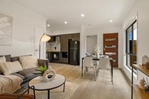una sala de estar con un sofá y una mesa en Cozy 2BR brandnew home at Brown Plains, en Browns Plains