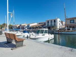 マルセイヤンにあるAppartement Marseillan-Plage, 2 pièces, 4 personnes - FR-1-387-45の船のマリーナの横に座るベンチ