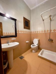 a bathroom with a sink and a toilet and a tub at Black Prince Hotel in Dahab