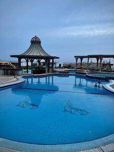 ダハブにあるBlack Prince Hotelの青い大型スイミングプール(ガゼボ付)