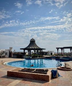a person swimming in a swimming pool with a gazebo at Black Prince Hotel in Dahab