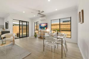 a dining room and living room with a table and chairs at Dual key 5BR Family home with stunning interior in Browns Plains