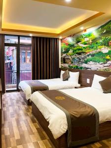 una habitación de hotel con 3 camas y un cuadro en la pared en Song Anh Hotel Sapa en Sa Pa