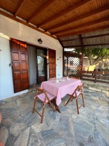 a table with a pink table cloth on a patio at Platanidia Guesthouse in Platanidia