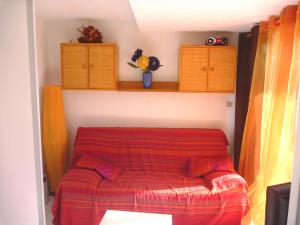 een bed in een kamer met een rode deken bij Appartement Marseillan-Plage, 2 pièces, 4 personnes - FR-1-387-70 in Marseillan