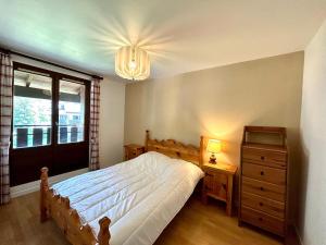 a bedroom with a bed and a dresser and a window at Appartement La Clusaz, 3 pièces, 8 personnes - FR-1-437-55 in La Clusaz