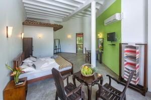 a bedroom with a bed and a table and chairs at VillaWatuna in Unawatuna