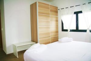 a bedroom with a white bed and a window at DakarByDays-DBD004-Appartement Amina 3 chambres in Dakar +23 photos