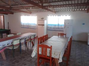 een keuken met een tafel en stoelen en een koelkast bij Chácara do vô Meireles in Serra Negra