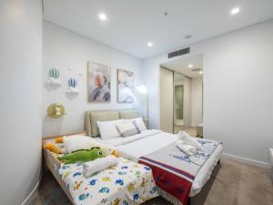 ein Schlafzimmer mit zwei Betten mit ausgestopften Tieren in der Unterkunft Stunning River views 2BR city centre Apt in Brisbane