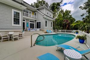 a house with a swimming pool and patio furniture at 317 Glen Eagle in Kiawah Island