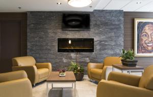 a waiting room with couches and a tv on a brick wall at Quality Inn Sept-Iles in Sept-Îles