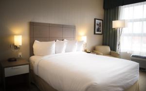 a large white bed in a hotel room at Quality Inn Sept-Iles in Sept-Îles +24 photos