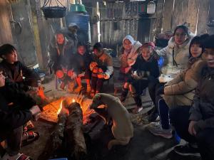 a group of people sitting around a fire at Stone Paradise Homestay in Sa Pa