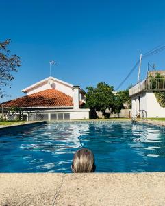 une personne regarde une piscine dans l'établissement Casa d'Avó Maria - Alojamento rural familiar, à Marco de Canavezes