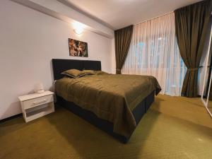 sypialnia z łóżkiem i oknem z zasłonami w obiekcie Silvia Chalet Poiana Brasov w Braszowie