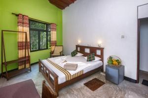 een slaapkamer met een bed in een kamer met groene muren bij VillaWatuna in Unawatuna +79 foto's