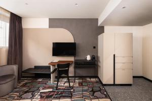 a hotel room with a desk and a tv at Hotel GIN Budapest in Budapest