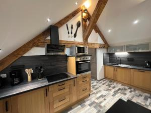 a large kitchen with wooden cabinets and appliances at Gîte Au Creux Du Moulin in Bussang