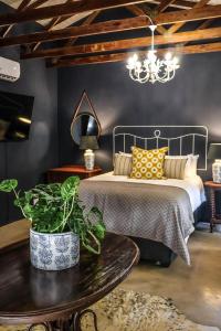 a bedroom with a bed with a table and a chandelier at 41 South in Mtunzini
