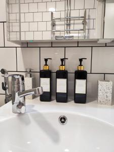 a bathroom sink with three bottles of soap at Studio in Kallio in Helsinki