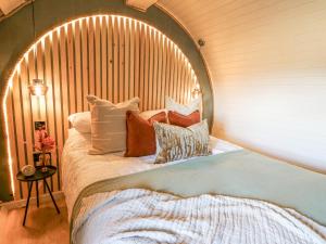uma cama com uma cabeceira de madeira com almofadas em Tan y Wawr- Onnen em Welshpool