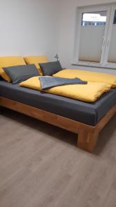 ein Bett mit einem Holzrahmen in einem Zimmer in der Unterkunft Gasthof Altes Farmhaus und Apartment in Lienen