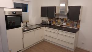 una cocina con armarios blancos y fregadero en Gasthof Altes Farmhaus und Apartment, en Lienen