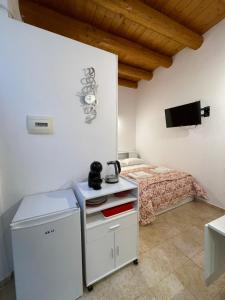 a bedroom with a bed and a table with a tea kettle on it at Il Cortiletto di Ortigia in Syracuse