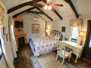 een slaapkamer met een bed en een plafondventilator bij Tiny Home Cottage Near the Smokies #7 Tilly in Sevierville