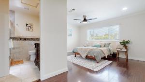 a white bedroom with a bed and a window at Dazzling Westside 4 Br Home-minutes To The Beach in Los Angeles