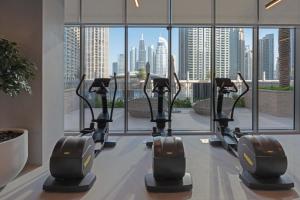 eine Reihe von Laufbändern in einem Fitnessraum mit Stadtblick in der Unterkunft 2-Bedroom in the Heart of Downtown Dubai in Dubai