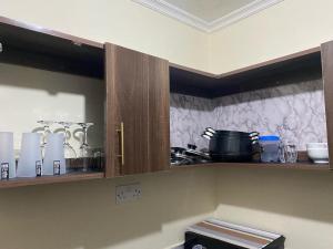a kitchen with wooden cabinets with utensils at Lakeside apartment in Kisumu