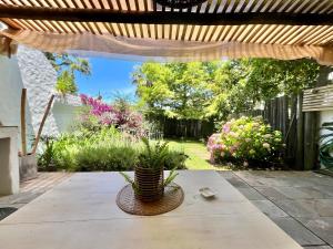 eine Terrasse mit einer Pergola und einem Tisch mit einer Pflanze in der Unterkunft Puerta Azul in Punta del Este