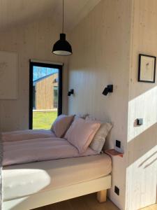 een bed in de hoek van een kamer met een raam bij Bjarmaland Cottages in Selfoss