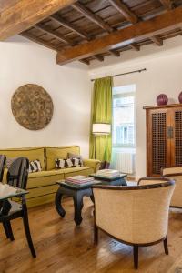 Residenza Clodio Spanish Steps في روما: غرفة معيشة مع أريكة صفراء وطاولات