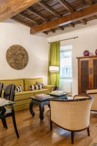 a living room with a yellow couch and tables at Residenza Clodio Spanish Steps in Rome