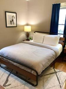 sypialnia z łóżkiem z poduszkami i lampą w obiekcie The House Hotels - Cohasset upper w mieście Lakewood