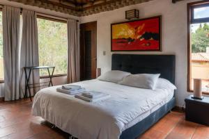 - une chambre avec un grand lit dans une pièce dotée de fenêtres dans l'établissement La Leyenda Apartamentos, à Villa de Leyva