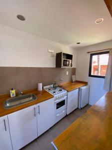 a kitchen with a sink and a stove top oven at Complejo Tajamar in Colón