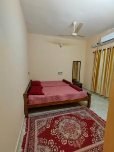 a bedroom with a bed and a red rug at Gerards Home stay Fortkochi in Cochin