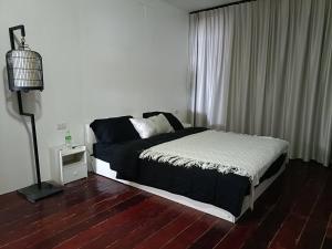 ein Schlafzimmer mit einem Bett und einer Lampe auf einem Holzboden in der Unterkunft Star house in Ko Lanta